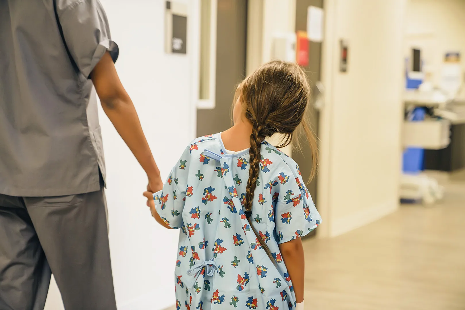 girl holding nurses hand walking in hospital