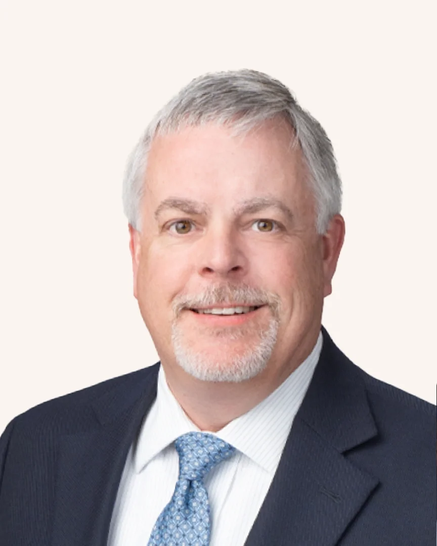 Headshot of a man smiling in a suit