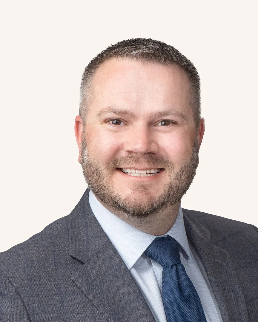 Headshot of a man smiling in a suit