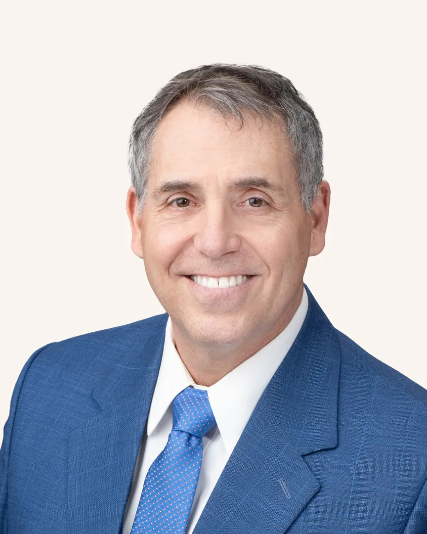Headshot of a man smiling in a suit
