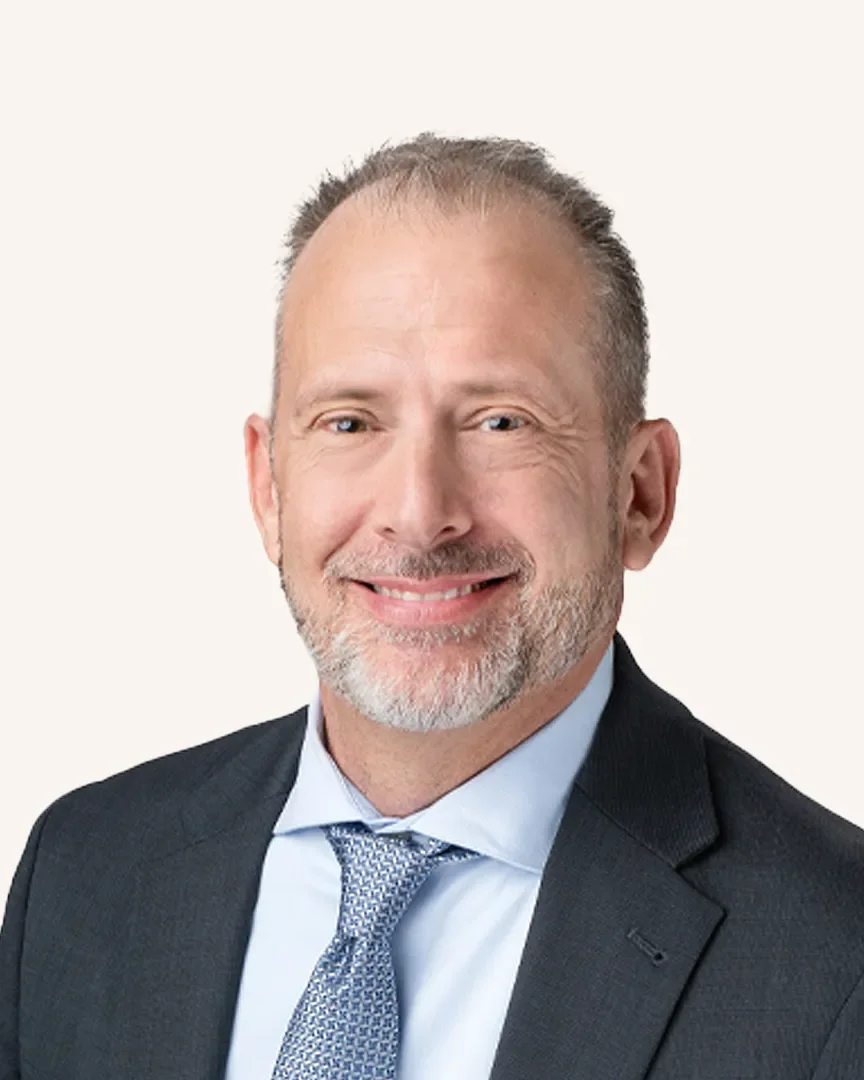 Headshot of a man smiling in a suit