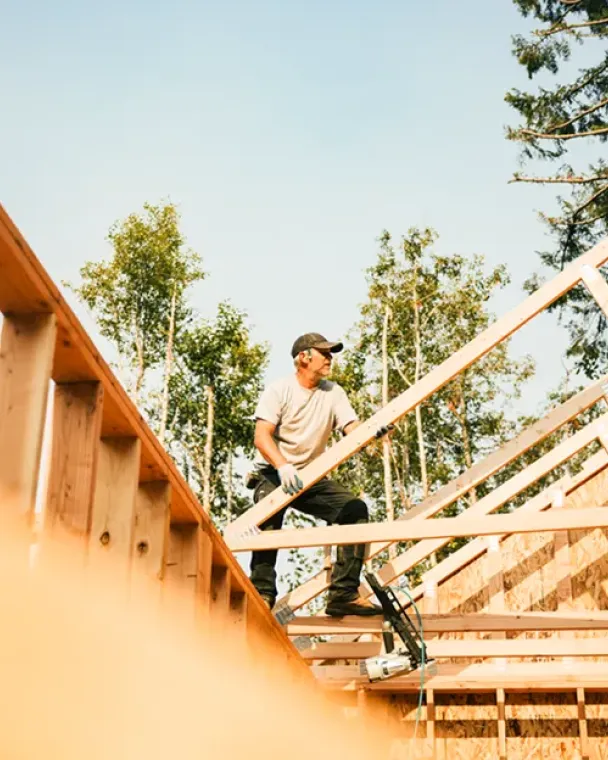 man assembling wood frame of building